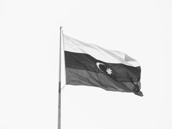 National flag of Azerbaijan flowing during national holiday against clear blue sky - central Baku black and white image — Stock Photo, Image