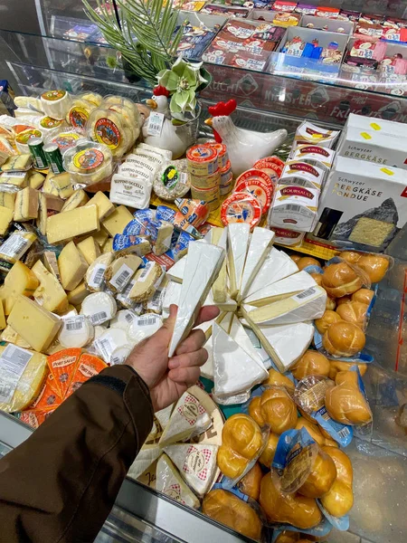 Vista interna del grande supermercato alimentare Edeka con più prodotti freschi sugli scaffali POV man holding fresh italian cheese — Foto Stock