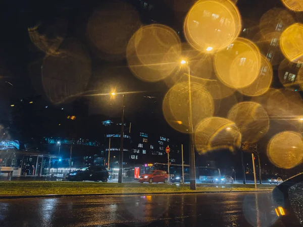 Cinematic bokeh na szkle z sylwetkami samochodów jadących w tle w deszczowy dzień we Francji — Zdjęcie stockowe