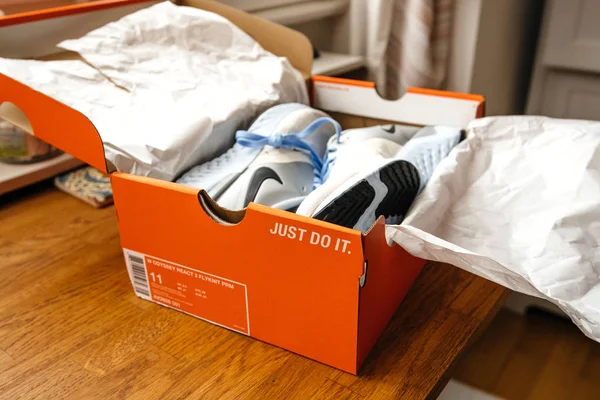 Unboxing unpacking on wooden table pair of new Nike female running professional shoes Nike Odyssey Reakt 2 Flyknit PRM — Stock Photo, Image