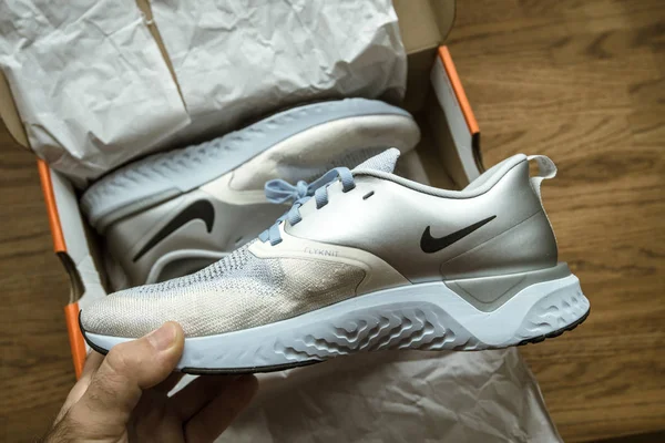 POV mano del hombre Unboxing desembalaje en la mesa de madera par de nuevos zapatos profesionales Nike mujer corriendo Nike Odyssey Reakt 2 Flyknit PRM — Foto de Stock