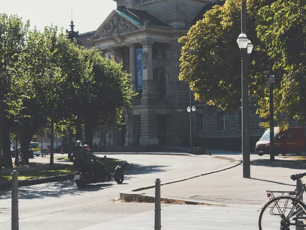 Dwóch mężczyzn na motocyklu jadących w pobliżu Palais Du Rhin w centrum Strasburga — Zdjęcie stockowe