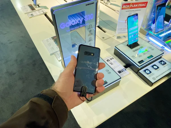 블랙 프라이데이가 시작되기 전에 최신 Smasung Galaxy S10 플래그 십 스마트폰 을 FNAC 프랑스 전자 매장 안에 들고 있는 남자 손. — 스톡 사진