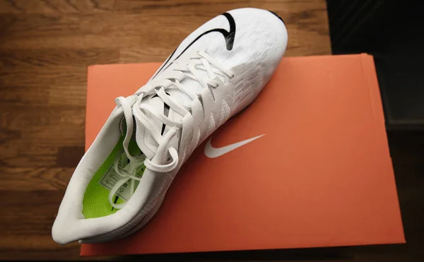 Bovenaanzicht op houten winkeltafel van unboxing proces professionele hardloopschoen vervaardigd door Nike model Zoom Rival Fly voor vrouwen met zwart swoosh logo — Stockfoto