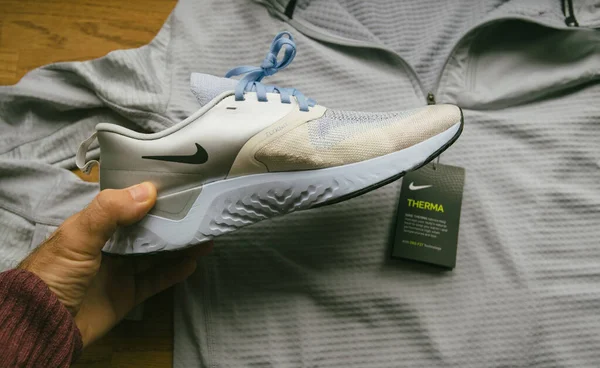 Pov man hand titta på de nya skor som tillverkas av Nike modell Odyssey React Flystickit 2 — Stockfoto