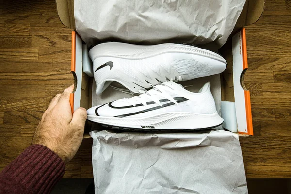 Pov man hand over doos tijdens het uitpakken van nieuwe paar professionele hardloopschoenen vervaardigd door Nike Zoom Rival Fly voor vrouwen — Stockfoto