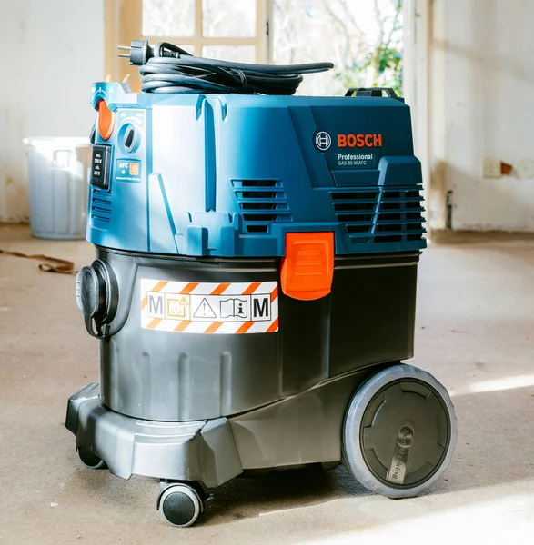 Vue de face du Bosch Professional Gas 35 M Class AFC avec extracteur automatique du système de nettoyage des filtres sur le sol en béton du chantier — Photo