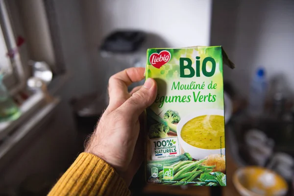 Man hand hålla mot kök bakgrund paket Biosoppa tillverkad köpa Leibig — Stockfoto