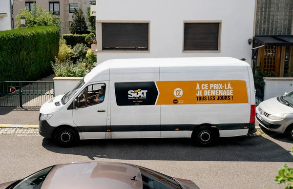 Vista aérea da Volkswagen van da Sixt alugar um serviço de aluguer de empresa de automóveis com motorista masculino falando no smartphone dentro da cabine — Fotografia de Stock