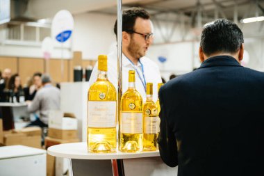 Strasbourg, France - Feb 16, 2020: Man near stand of white French wine at the Vignerons independant English: Independent winemakers of France wine fair for private and horeca customers