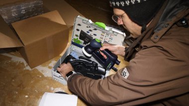 Strasbourg, Fransa - 3 Mart 2020: Erkek işçi boks paketini açıyor. Çoklu kullanım Festool Rotex Ro 90 Dx Feq-Plus Sander