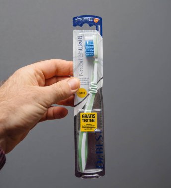 Paris, Fransa - 5 Mart 2020: Kare resim Pov erkek eli, Dr Best diş fırçasını gri arka planda büyük sarı Gratis testen Alman çıkartmasıyla tutuyor