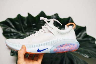 Yeşil yaprak bitkisine karşı atlet el ele tutuşması Nike Sports 'un en son icadı Joyride koşu ayakkabıları ve daha iyi destek için binlerce top.