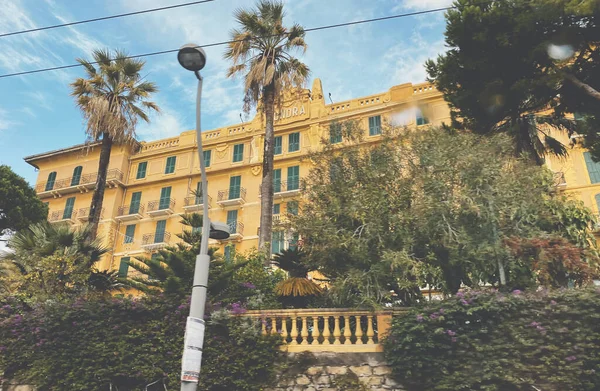 Вид с улицы роскошного Grand Hotel de Londres в центре Санремо с высокими пальмами и желтым фасадом — стоковое фото