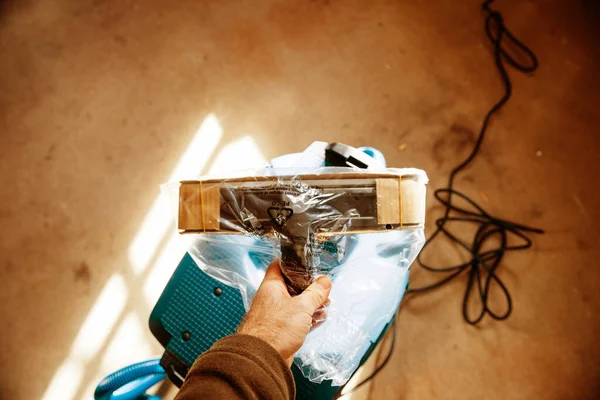 Overhead view of male hand holding new unboxed unpacked vacuum cleaner professional brush used in construction industry Bosch Professional tool — Stockfoto