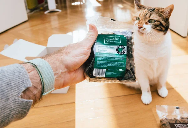 Férfi kínál macska csomag friss Chewies képzés Maxi száraz kutyaeledel Tripe csontok — Stock Fotó