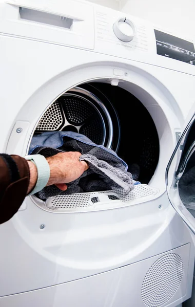 Чоловіча рука заповнює пральну машину для сушіння — стокове фото