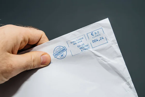 Sobre de papel francés de mano masculina Lettre Prioritaire Prioridad del operador postal de la Poste con un precio de sello de 4,24 euros enviado desde Schiltigheim Bas-Rhin — Foto de Stock