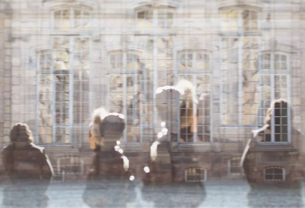 큰 창문을 배경으로 프랑스 거리를 걷고 있는 실루엣 사람들 — 스톡 사진