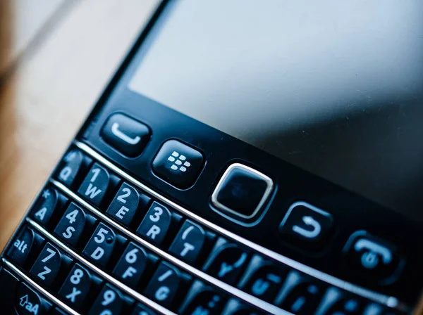 Przechylna soczewka makro używana na smartfonach Blackberry Palm vintage produkowanych przez nieistniejącą firmę Blackberry z pełną klawiaturą Qwerty na przycisku domowym i zadrapaniami na wyświetlaczu — Zdjęcie stockowe