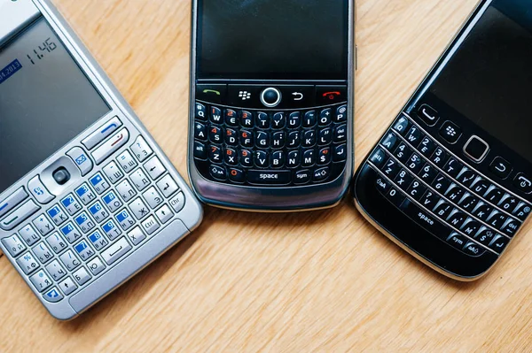 Visão aérea de três smartphones modernos telefones fabricados pela Nokia e Blackberry com teclado qwerty completo — Fotografia de Stock