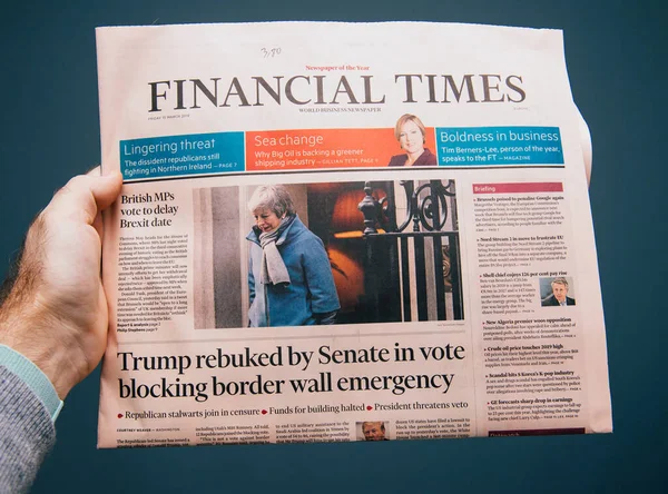 Mężczyzna ręka Pov w najnowszym wydaniu Financial Times gazety featuring najnowsze wiadomości o Brexit, Theresa może i Trump zgromiony przez Senat — Zdjęcie stockowe