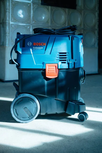 Coulée bleue Vue de face de Bosch Professional Gas 35 M Class AFC avec extracteur automatique de système de nettoyage de filtre avec Kachelofe en arrière-plan — Photo