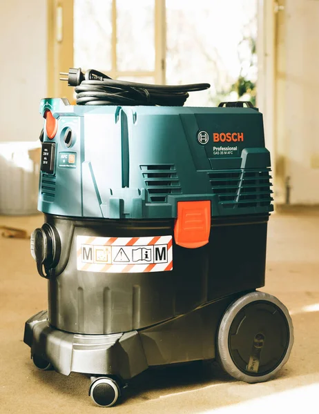 Vista frontale di Bosch Professional Gas 35 M Class AFC con estrattore automatico del sistema di pulizia del filtro sul pavimento in calcestruzzo del cantiere — Foto Stock