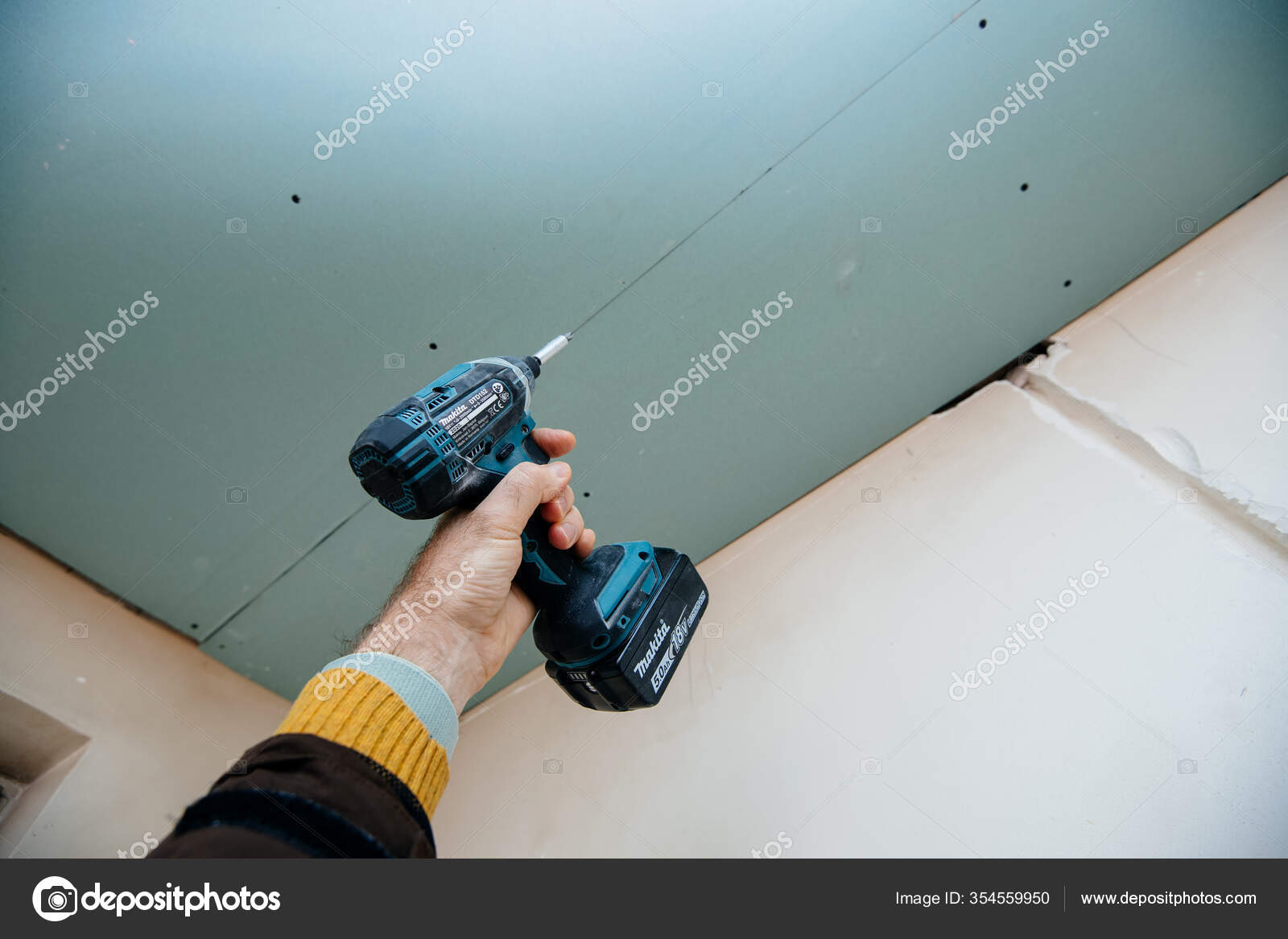 POV male construction hand holding Makita DTD152 18V Cordless Impact Driver  with green plasterboard – Stock Editorial Photo © ifeelstock #354559950
