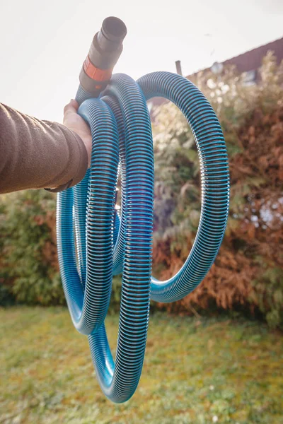 Professionell arbetare man hand hålla mot grön trädgård bakgrund nya blå antistatisk vakuum slang — Stockfoto
