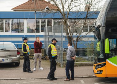 Beyaz koruma maskesi takan şehirlerarası otobüs şoförü ve Kehl sınır kapısındaki polis kontrol noktası.