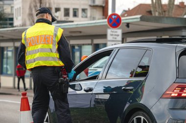 Bundespolizei polisi sınır kapısındaki trafiği kontrol ediyor.
