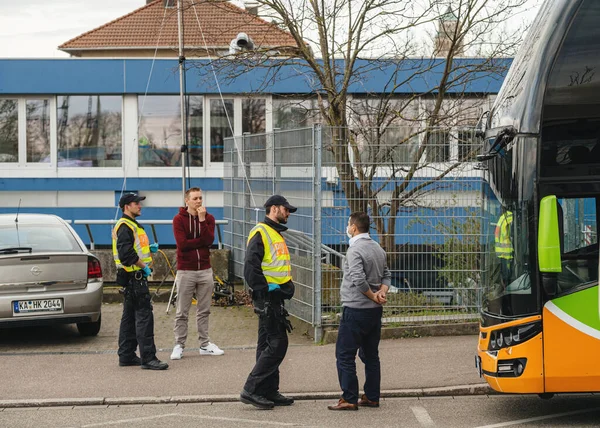 Conductor de autobús interurbano con máscara de protección blanca y puesto de control de inspección de oficiales de policía en el cruce de fronteras Kehl — Foto de Stock