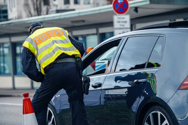 Vista trasera del oficial de policía que inspecciona el coche en el cruce fronterizo de Kehl — Foto de Stock