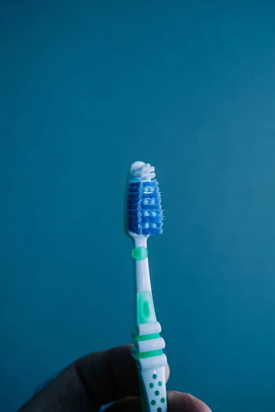 Man hand holding new toothbrush isolated background — Stock Photo, Image