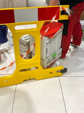 Erkek İşçi ayakları sarı koruma işaretinin yanında ve birden fazla Festool temsilcisi