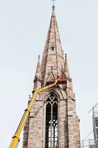 Werknemers op hoog hefplatform repareren van de kerkgevel — Stockfoto