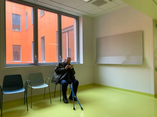 次の診察手術のために病院の部屋で待っている杖を持つシニア男 — ストック写真