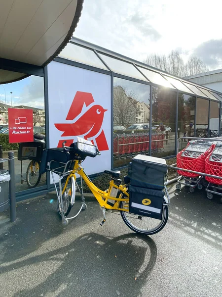 Boş Auchan süpermarketinin önünde elektrikli bisiklet teslimatı