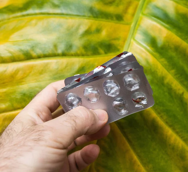 Wiele tabletek puste pęcherze przed zielony kwiat tło uzależnienie od narkotyków — Zdjęcie stockowe