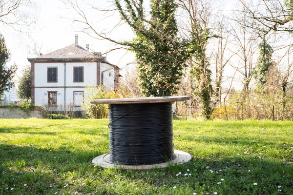 Fiber optic roll in garden with house in background — Stock Photo, Image