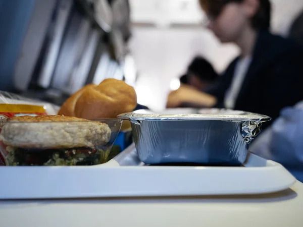 Aircraft meal during long transatlantic flight covered in special heat protection envelopes — Stock Photo, Image