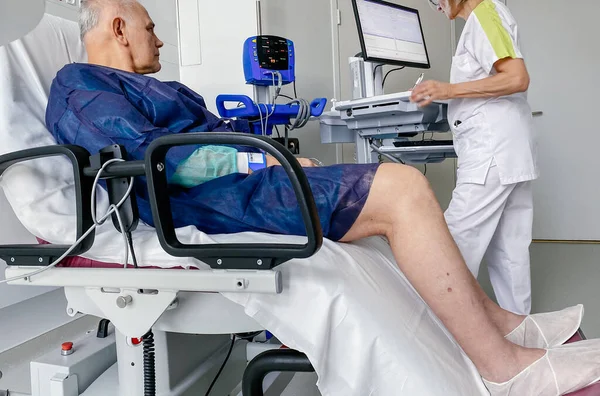 Curious attentive senior male on modern medical chair inside modern hospital in France — Stock Photo, Image