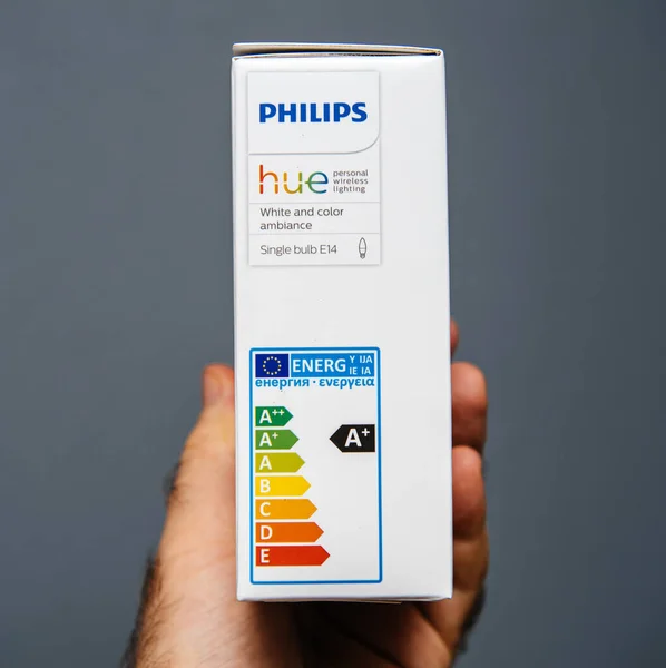 Señalización de etiqueta energéticamente eficiente mano masculina que sostiene la nueva caja del paquete de Philips Hue — Foto de Stock