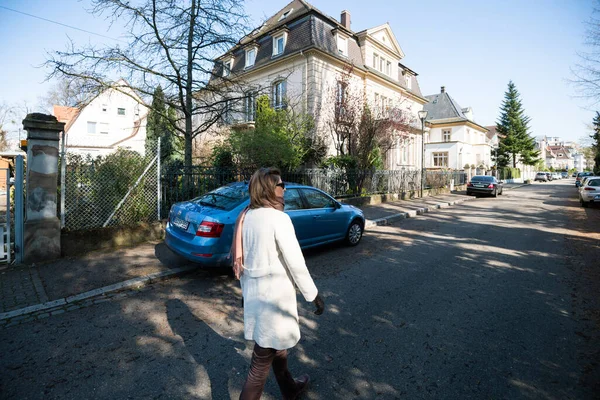 Seitenansicht der Französin zu Fuß in der Nähe von Haus und Skoda Octavia — Stockfoto