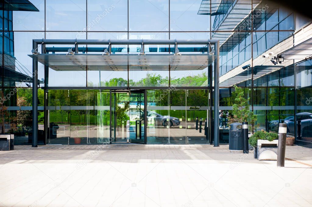Main entrance to business building convenience center with glass doors and steel frame construction