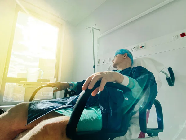 Idős férfi alszik fekszik az orvosi széken belül modern kórház Franciaországban coronavirus — Stock Fotó