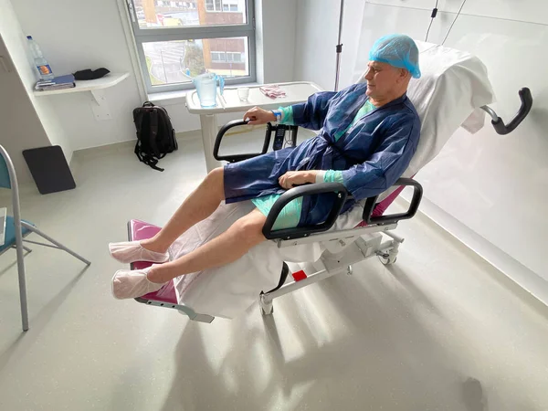 Förhöjd syn på att ligga på den medicinska stolen senior hane inne modernt sjukhus — Stockfoto