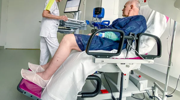 Sittande äldre man på modern medicinsk stol inne på modernt sjukhus — Stockfoto