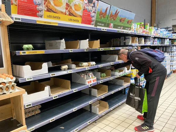 Senior shopping maschile per le ultime uova nel supermercato alimentare nella città francese durante il blocco pandemico Coronavirus — Foto Stock